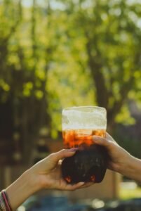 Hands holding a cold beverage outdoors, capturing a summer moment in Buenos Aires, Argentina.